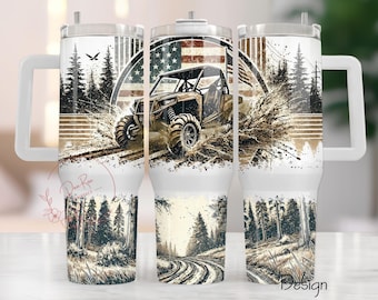 May include: White stainless steel tumbler with a design of an off-road vehicle driving through mud and an American flag. The tumbler has a black lid and a handle.