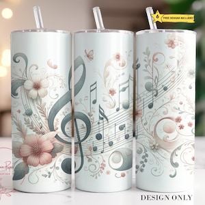 May include: A white tumbler featuring a design of musical notes, a treble clef, and floral elements in shades of pink and grey. The design is reminiscent of a vintage music score.