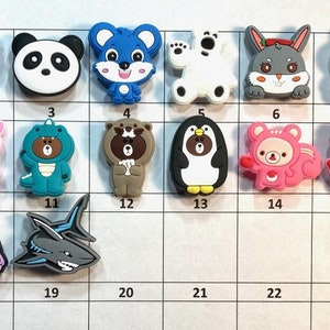 Puede incluir: Un conjunto de 24 amuletos de personajes de dibujos animados coloridos, que incluyen animales como pandas, búhos, pingüinos y pollitos. Los amuletos están numerados del 1 al 24.