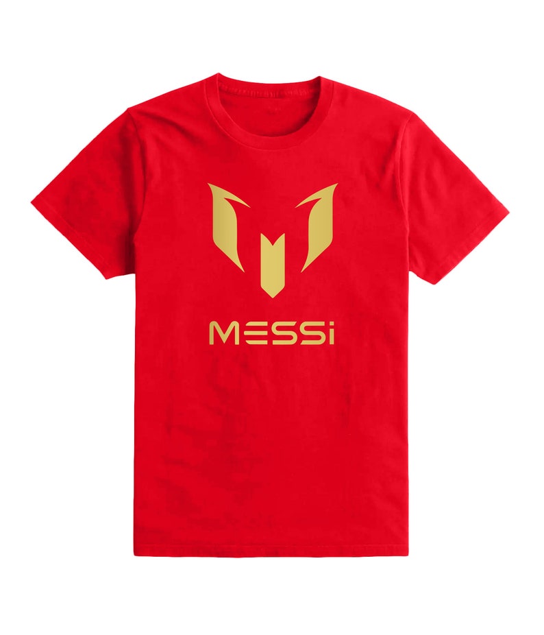 Op de afbeelding: Rood T-shirt met een gouden logo van een gestileerde "M" en het woord "MESSI" eronder.