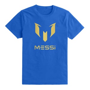 Op de afbeelding: Een koninklijk blauw t-shirt met een gouden logo en het woord "MESSI" gedrukt op de voorkant.
