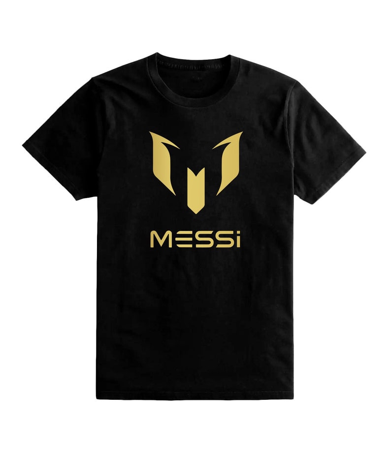 Op de afbeelding: Zwart T-shirt met een gouden "M" logo en het woord "MESSI" gedrukt op de voorkant.