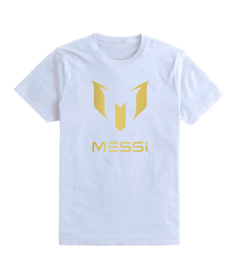 Op de afbeelding: Wit T-shirt met een gouden afbeelding van de letter "M" en het woord "MESSI" eronder.