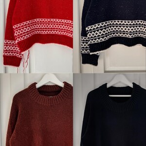 Könnte beinhalten: Vier verkürzte Pullover in verschiedenen Farben: Rot, Marineblau, Burgunderrot und Dunkelblau. Jeder Pullover hat ein weißes geometrisches Muster am unteren Saum.