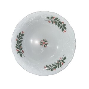 May include: White ceramic serving bowl with a scalloped edge and embossed floral design. The bowl is decorated with green holly leaves and red berries, creating a festive holiday theme.