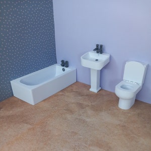 May include: A white bathroom suite with a bath, sink, and toilet. The bathroom is decorated with a blue and white patterned wallpaper.