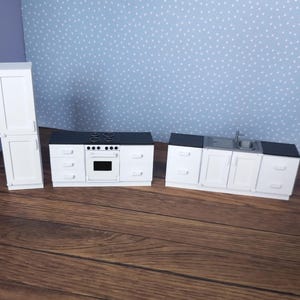 May include: White miniature kitchen set featuring a refrigerator, oven, sink, and cabinets. The set is made of plastic and is ideal for dollhouses or play kitchens.