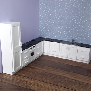 Peut inclure: Des armoires de cuisine blanches avec des plans de travail noirs et un réfrigérateur blanc. Les armoires ont un design moderne et sont disposées en configuration d'angle.