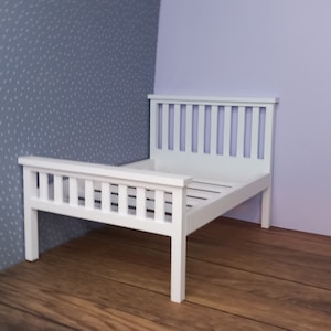 May include: A white wooden bed frame with a slatted headboard and footboard. The bed is sitting on a wooden floor.