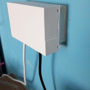 May include: A white electrical outlet cover with two black wires coming out of it. The cover is mounted on a light blue wall.