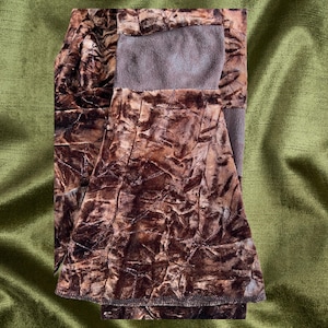 May include: A brown velvet skirt with a crinkled texture. The skirt has a brown waistband and a brown lining.