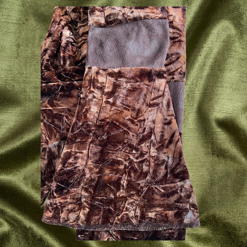 May include: A brown velvet skirt with a crinkled texture. The skirt has a brown waistband and a brown lining.