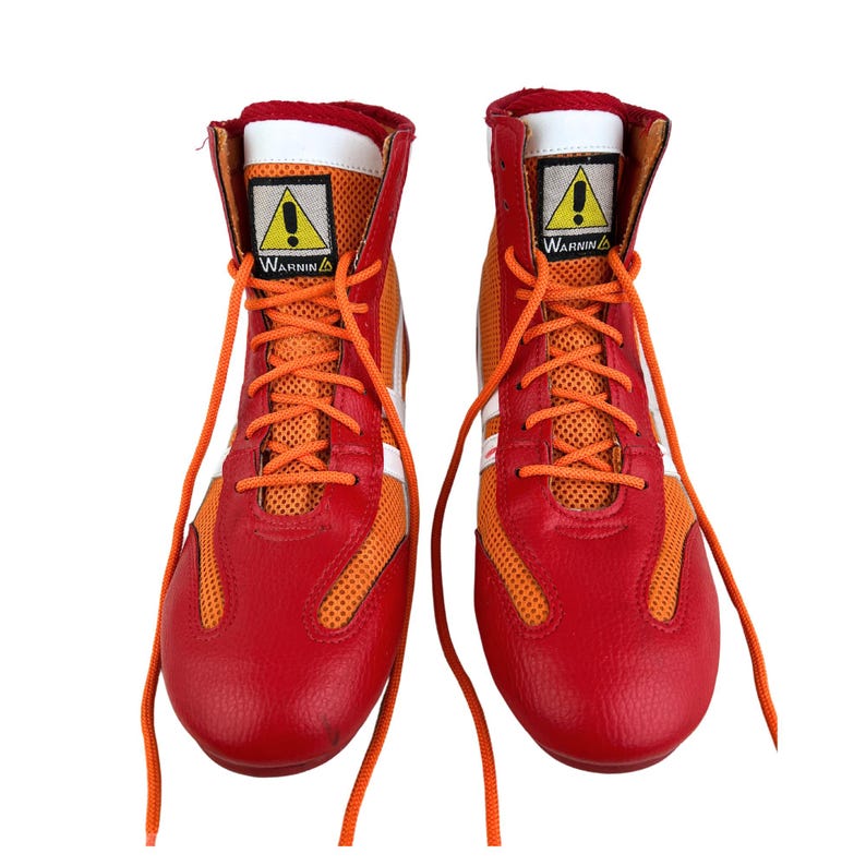 May include: A pair of red and orange boxing shoes with white laces and a yellow warning sign on the side. The shoes have a mesh panel on the side and a white stripe around the top.