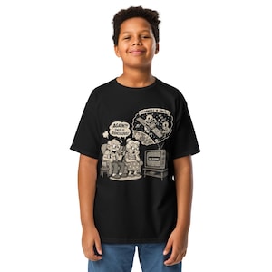 Könnte beinhalten: Schwarzes T-Shirt mit einer Cartoon-Illustration. Die Grafik zeigt ein älteres Ehepaar, das fernsieht, mit den Worten "AGAIN?! THIS IS RIDICULOUS!" und einer Weltraumszene mit den Worten "MEANWHILE IN SPACE..." Der Fernsehbildschirm zeigt "NO SIGNAL."