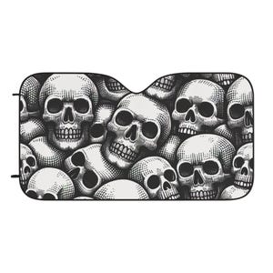May include: Black and white car sunshade featuring a repeating pattern of detailed skull illustrations. The skulls are in various sizes and orientations, creating a dense, macabre design. The sunshade has a curved top edge.
