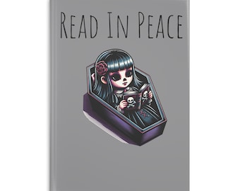 Może przedstawiać: Szary notes z tekstem "READ IN PEACE" w czarnych literach. Rysunkowa ilustracja dziewczyny z czarnymi włosami i czarną sukienką leżącej w trumnie i czytającej książkę z czaszką i skrzyżowanymi kośćmi na okładce.