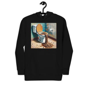 May include: Black hoodie featuring a graphic of a toilet with overflowing contents. The artwork depicts a white toilet with a wooden seat, set against a backdrop of a tiled wall and wooden floor. The design is humorous and eye-catching.