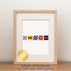 May include: A framed cross-stitch pattern displaying a sequence of colourful nautical signal flags. The flags are in blue, yellow, red, and white. The text at the bottom reads "orleans, massachusetts zip code cross stitch pattern."