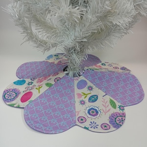 Easter Tabletop Tree Skirt. 12" petal shaped lightly quilted holiday skirting. Bunnies, eggs, flowers and more on purple and pink fabrics.