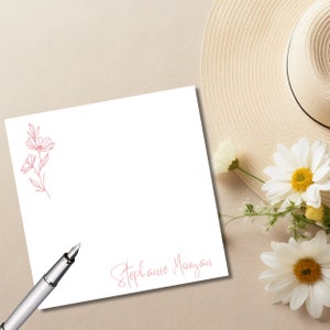 May include: A white card with a pink floral design and the text "Stephanie Morgan" in pink script.