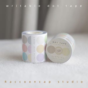 May include: Two rolls of pastel colored dot tape with the text "Solid color dots 1" and "DOT TAPE Writable Dot Stickers 5cm x 5.3m 87cm/1sQP" on the labels. The tape is designed for writing on.