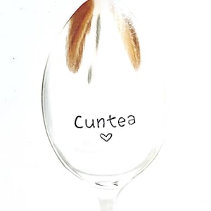 May include: A silver spoon with the words "Cuntea" and a heart written on it.