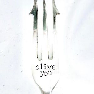 May include: A silver fork with the words "olive you" engraved on the handle.