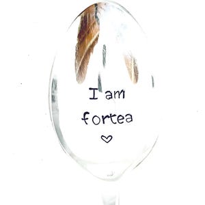Könnte beinhalten: Ein silberner Löffel mit dem Text "I am fortea" und einem kleinen Herz, das auf die Vorderseite graviert ist.