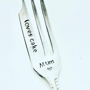 May include: Silver fork with the words "Mum" and "loves cake" engraved on it. A small heart is engraved next to the word "Mum".