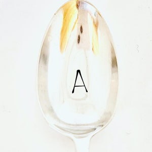 Könnte beinhalten: Ein silberner Löffel mit dem Buchstaben "A" auf der Vorderseite graviert.