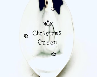 May include: A silver spoon with the words "Christmas Queen" engraved on it. A crown is above the words.