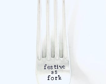 May include: A silver fork with the words "festive as fork" engraved on the handle.