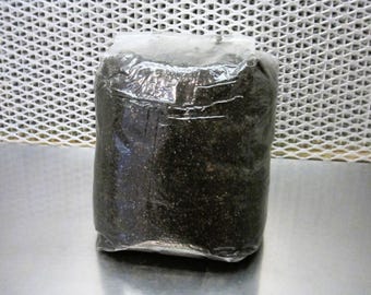 May include: A black bag of potting soil wrapped in clear plastic.