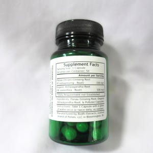 May include: Green plastic bottle with a white label that reads "Supplement Facts". The label lists the ingredients and dosage of Panax Ginseng Root and Organic Ashwagandha Root. The bottle contains green capsules.