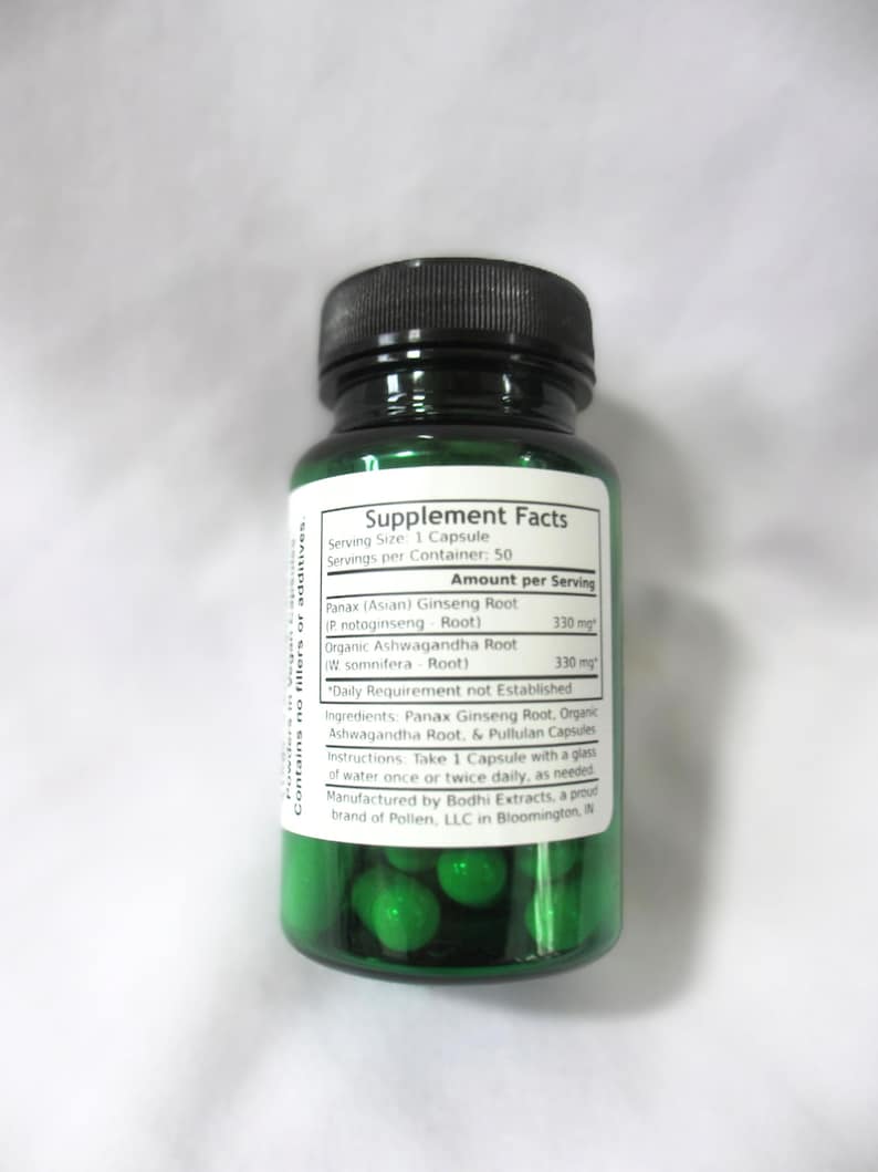 May include: Green plastic bottle with a white label that reads "Supplement Facts". The label lists the ingredients and dosage of Panax Ginseng Root and Organic Ashwagandha Root. The bottle contains green capsules.