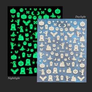 May include: Two sheets of Halloween-themed nail art stickers. One sheet glows in the dark with green images of pumpkins, ghosts, and bats. The other sheet has white images of the same designs. The text "WG667" is visible.