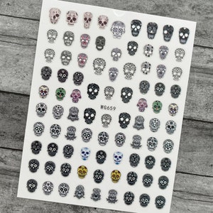 May include: Sheet of nail art stickers featuring various sugar skull designs in black, white, and colorful accents. The skulls have intricate patterns and details. The text "WG659" is printed on the sheet.
