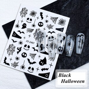 May include: Black and white Halloween nail art stickers featuring spiderwebs, bats, ghosts, and skulls. The sheet includes the text "JO-2497". The image also shows several nails decorated with the stickers. The text "Black Halloween" is also present.