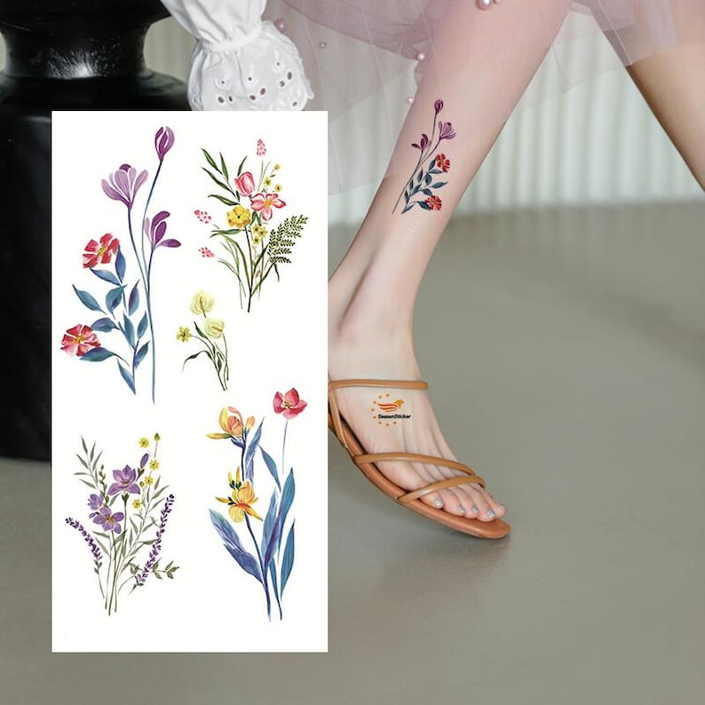 Puede incluir: Una hoja de tatuajes florales temporales con varios dise&ntilde;os de flores coloridas. Los tatuajes incluyen flores rojas, moradas, amarillas y azules con hojas verdes. Un peque&ntilde;o tatuaje floral tambi&eacute;n es visible en una pierna.