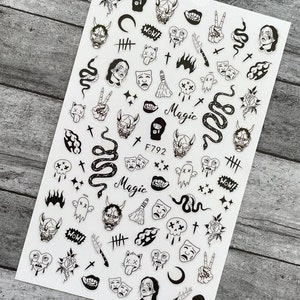 May include: Black and white nail art stickers featuring various designs, including skulls, snakes, crosses, demons, and the word "Magic".