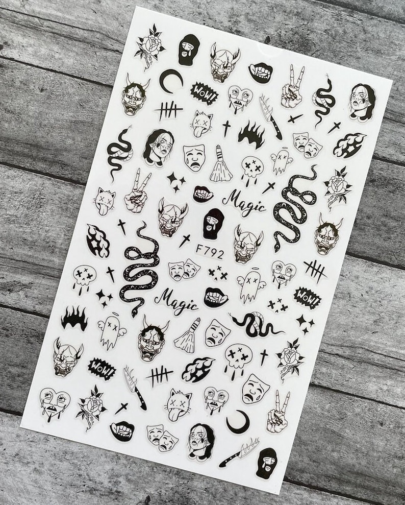 May include: Black and white nail art stickers featuring various designs, including skulls, snakes, crosses, demons, and the word "Magic".