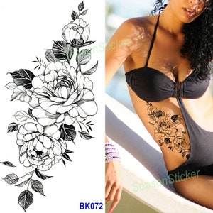 Pu&ograve; includere: Tatuaggio temporaneo in bianco e nero con un design floreale con grandi fiori dettagliati e foglie. Il tatuaggio &egrave; mostrato sul fianco di una persona.