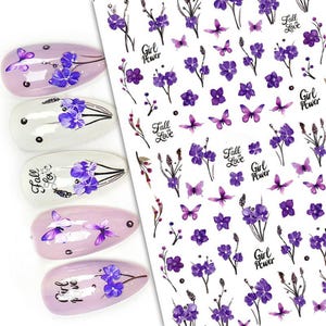 May include: Nail art stickers with purple flowers, butterflies, and the text "Fall in Love" and "Girl Power".
