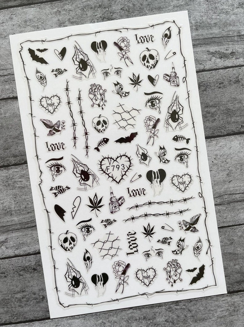 May include: A sheet of black and white stickers featuring various gothic and grunge-inspired designs. The stickers include hearts, eyes, spiders, bats, flowers, and more. The text "Love" and "Hate" appears on some of the stickers.  F793 is also printed on one of the stickers.