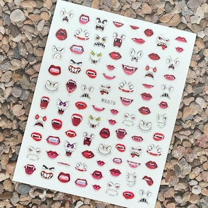 Könnte beinhalten: Bogen mit Nagelkunst-Aufklebern mit verschiedenen Cartoon-Monstergesichtern und roten Lippen. Die Aufkleber zeigen verschiedene Ausdrücke mit Fangzähnen, wütenden Augen und offenen Mündern. Auf dem Bogen steht der Text "WG676".