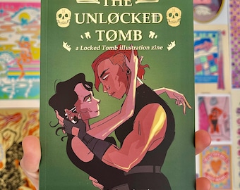 May include: A green zine titled "THE UNLOCKED TØMB" with gold lettering and skull illustrations. The cover art features two figures embracing. The zine is subtitled "a Locked Tomb illustration zine" and is by En Nelson-Correia.