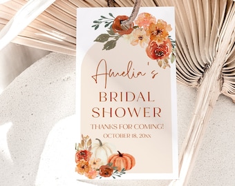 May include: A peach-colored bridal shower thank you tag with a watercolor illustration of orange and yellow flowers, green leaves, and two pumpkins. The text reads "Amelia's Bridal Shower Thanks for coming! October 18, 20XX".