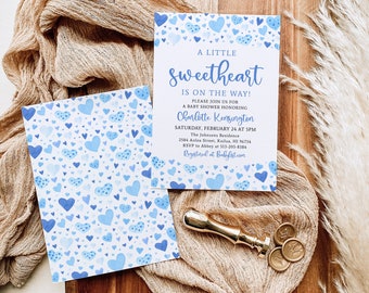 May include: A baby shower invitation with a blue and white watercolor heart pattern. The invitation reads "A Little Sweetheart is on the Way!" and includes the name Charlotte Kensington, the date and time of the shower, the address, and RSVP information.