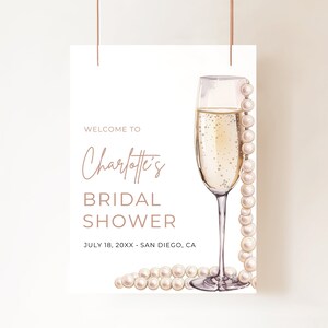 May include: A white bridal shower invitation with a champagne flute and pearls. The text reads "Welcome to Charlotte's Bridal Shower July 18, 20XX - San Diego, CA"
