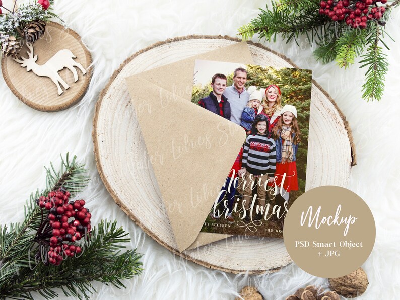 May include: A Christmas card mockup with a brown envelope and a photo of a family in front of a Christmas tree. The card reads "Merriest Christmas" in white script. The mockup is on a wooden background with a brown circle that says "Mockup PSD Smart Object + JPG".